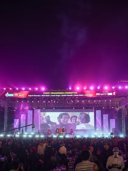 The stage is bathed in purple light as a band performs for the massive crowd at the Goregaon Sports Club. We provide complete lighting design and technical support for all our live events.