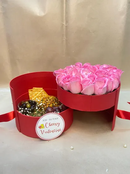 For a 'Cheesy Valentine', this clever two-tiered box separates a bouquet of pink roses from a selection of cheese and crackers. It's a fun and delicious twist on the classic romantic gift.
