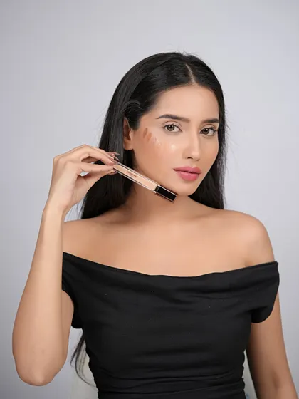 This shot demonstrates the concealer shades swatched on the model's cheek, providing a practical and informative view for customers.