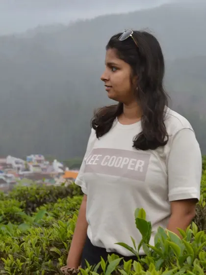 A candid shot of a traveler looking out over the tea estates and the town below.