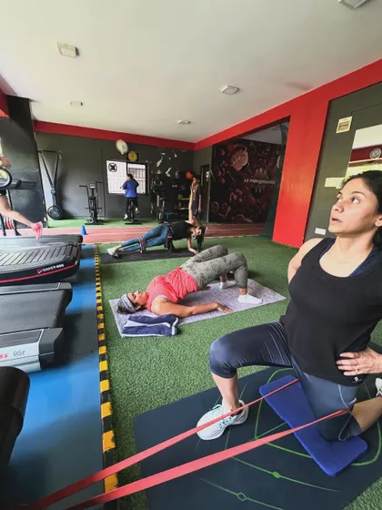 A group of clients works through various exercises, including stretches and core work, showcasing the supportive group environment.