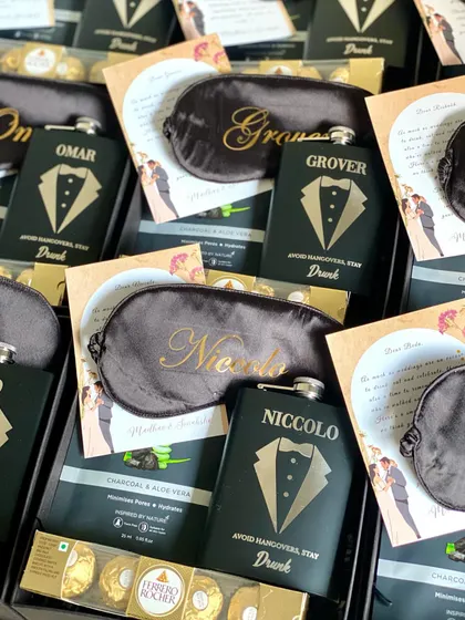 The details matter! I make sure every groomsman's name is perfectly placed on their personalized gifts, like these custom eye masks and hip flasks.