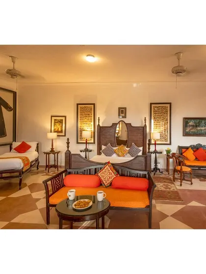 This photograph of a hotel room showcases the blend of traditional wooden furniture and cultural artifacts, creating an authentic and comfortable atmosphere for guests.