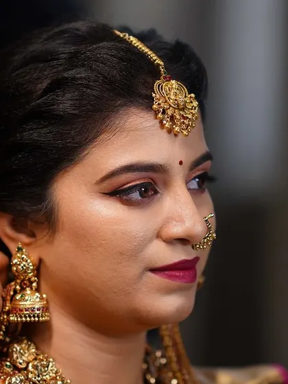 The final touches being added to Meghana's bridal hairstyle, adorned with fresh flowers.