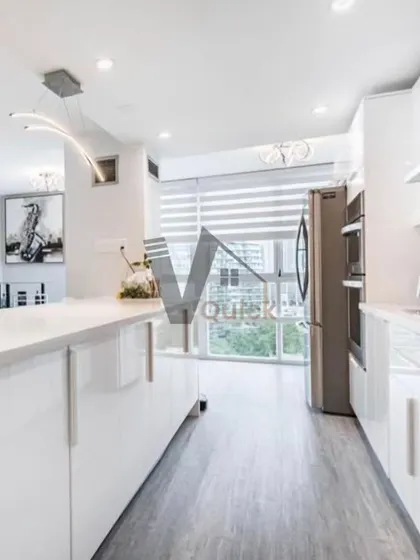 This all-white modular kitchen is the definition of modern elegance. The handleless cabinets, integrated appliances, and waterfall island countertop create a seamless and minimalist look. It's a bright, clean, and highly functional kitchen design.