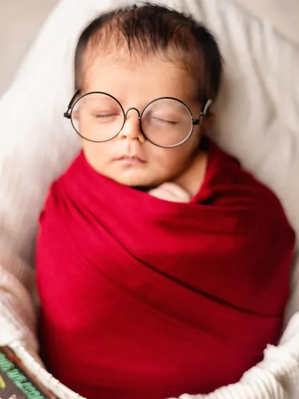 Even the tiniest wizards need their sleep. A close-up of a newborn in a Harry Potter-inspired wrap and glasses, this shot is all about capturing magical details.