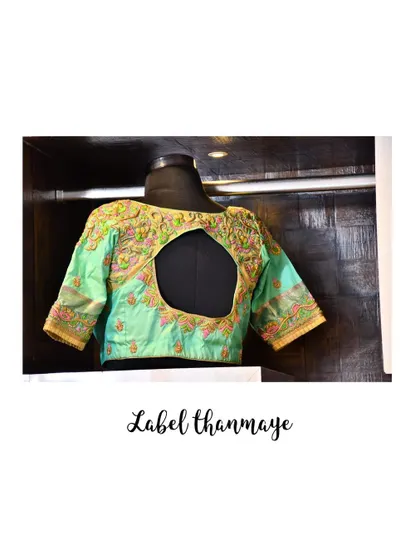A light green bridal blouse with a large keyhole back and multi-colored floral embroidery.