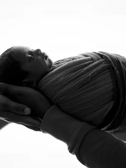 Held aloft by love. This symbolic silhouette of parents' hands lifting their baby is a powerful and artistic representation of family and support.