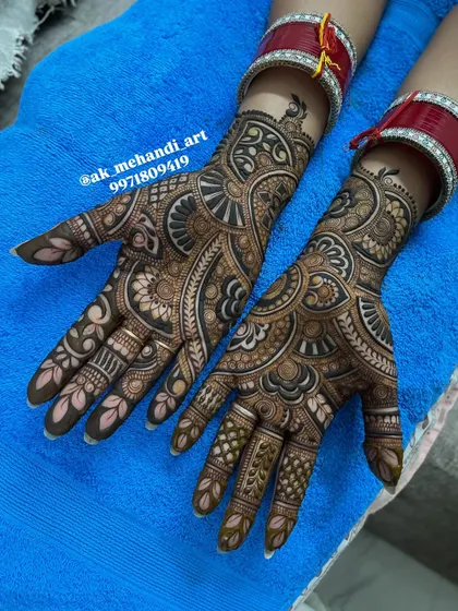 A classic Karwachauth or bridal design featuring traditional Rajasthani elements. The inclusion of the red bridal bangles, or 'chooda', shows how the mehndi complements the complete bridal attire.