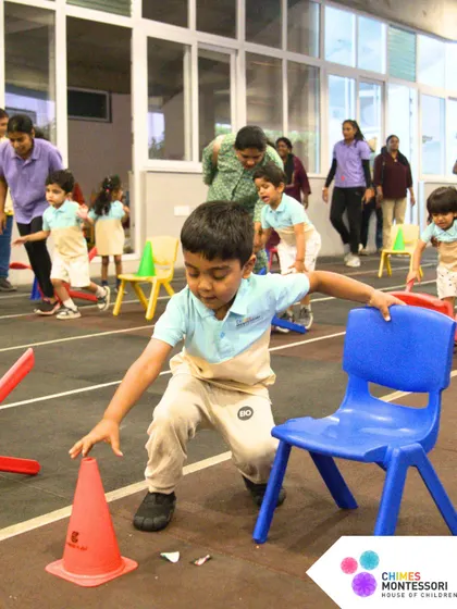 An obstacle course on Sports Day challenges children to navigate cones and chairs, building agility and problem-solving skills.