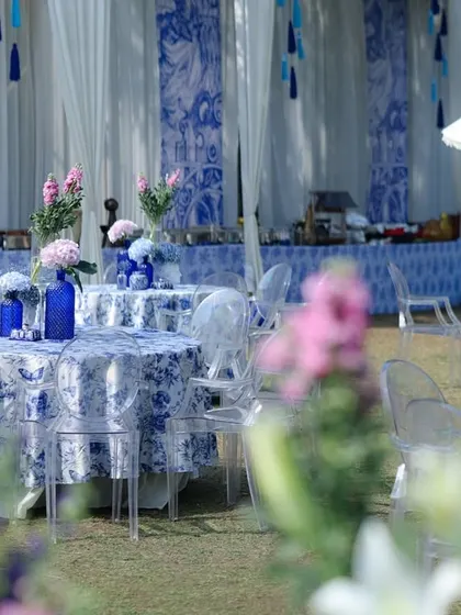Another view of the dining area, with the camera focused through foreground flowers, creating a soft and dreamy image of the blue and white tables.