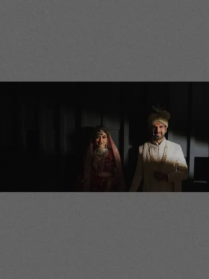 A dramatic, high-contrast shot of the couple emerging from the shadows. The play of light is central to this artistic and moody portrait.