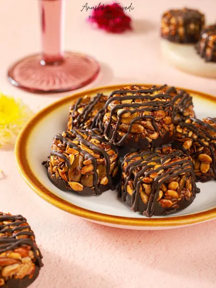 A close-up of the chocolate-drizzled nut clusters, highlighting their crunchy texture and glossy finish.