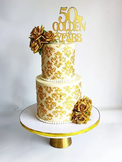 Royal and radiant! This two-tier cake with gold stenciling and golden roses was for a 50th 'Golden Years' celebration, but it would be equally stunning as a wedding cake.