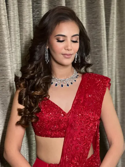 A close up on the finale look. The soft glam eye makeup and perfectly contoured cheeks complement the sparkling red saree and diamond jewelry, creating a look that is pure Hollywood glamour.