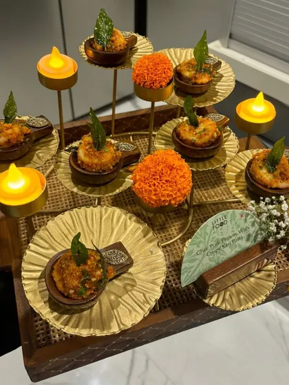 A beautifully arranged tray of our Chili Paneer Paniyaram with Creamy Chili Dip. The presentation with mini diyas and marigold petals makes it perfect for a festive Diwali celebration.