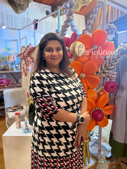 A photo of me at The Pink Post Inc exhibition, surrounded by my creations. It was a joy to meet so many people and share my passion for creating beautiful, memorable party setups.