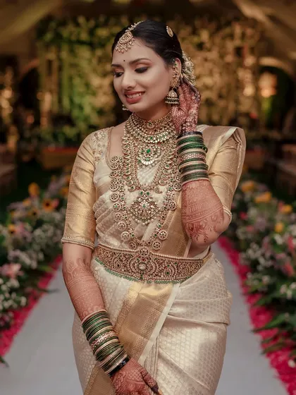 A beautiful shot of the bride on her wedding day, the floral decorations in the background adding to the festive atmosphere.