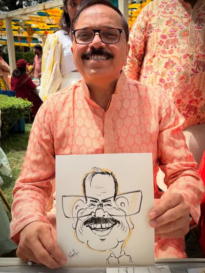 A guest proudly displays his caricature, a fun memory from a beautiful wedding in the hills.