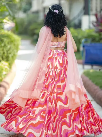 A back view of her Haldi look, showing the half-updo with a floral accessory. It's a practical and beautiful style for this event.