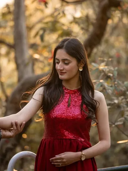 A tender moment as he leads her by the hand. The focus is on their connection, with the soft, natural background creating a romantic mood.