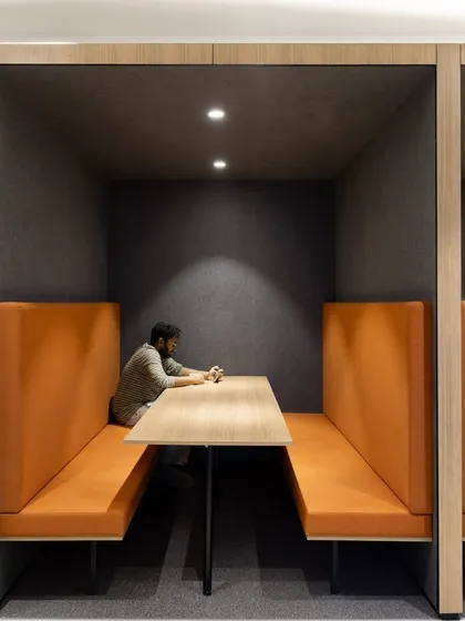 A solitary moment of focus within a collaboration pod at the Sushee office. The acoustic paneling and contained design create a quiet zone for concentration, illustrating our commitment to designing functional spaces that cater to diverse work styles.