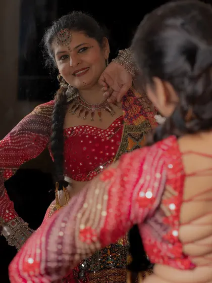 Admiring the details of my custom-designed Navratri outfit, complete with a mirror-work blouse and traditional jewelry.