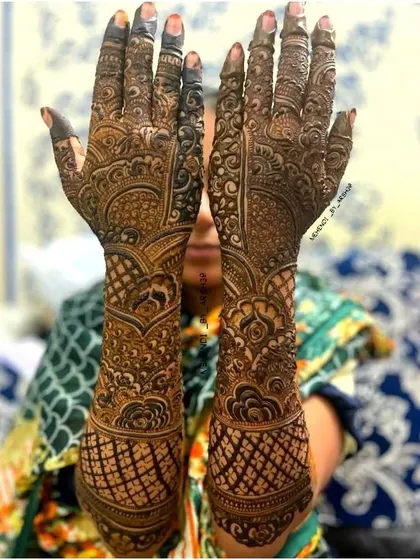 A classic bridal henna pose showing the detailed artwork on both the front and back of the hands. I focus on creating symmetrical yet unique patterns for each hand that complement each other perfectly.