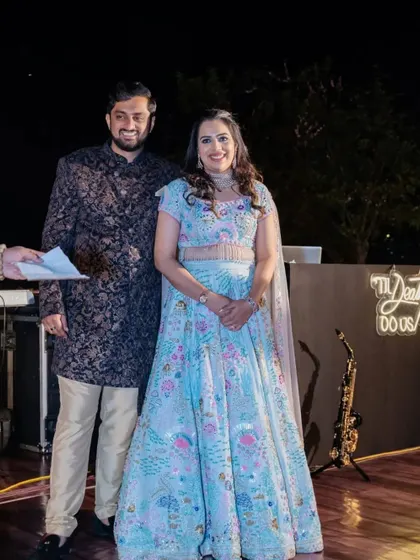 The bride and groom on their Sangeet stage, sharing a smile. We ensure the lighting and backdrop are perfect for capturing these precious memories.