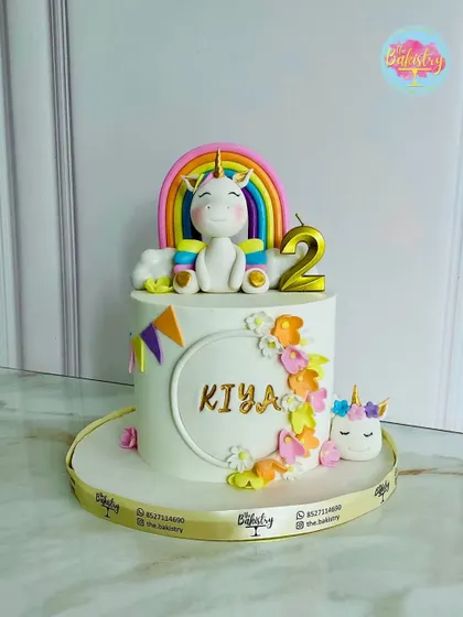 A magical unicorn-themed cake for Kiya’s 2nd birthday. This enchanting creation features a happy unicorn sitting in front of a vibrant rainbow, surrounded by flowers.