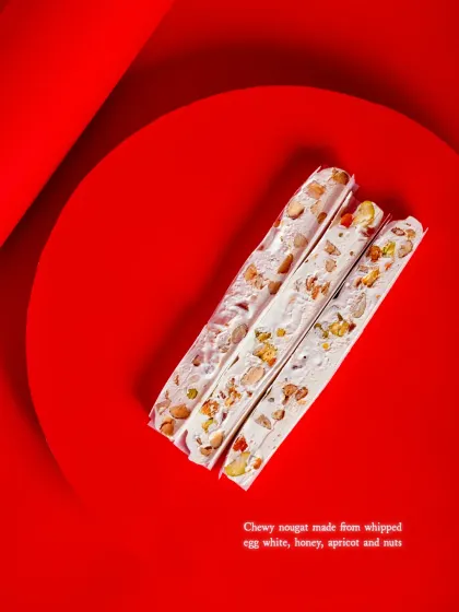 A description of the chewy nougat, made from whipped egg white, honey, apricot, and nuts.