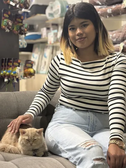 A serene moment shared between a cat and her parent. Our café is a calm oasis for our feline friends too.