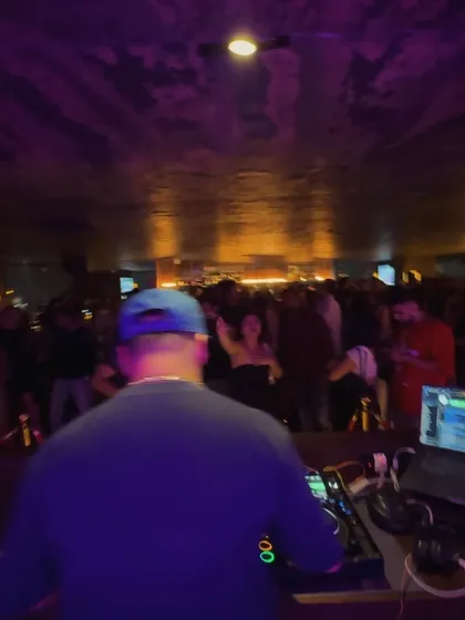 Another view from behind the decks, showing the packed and energetic rooftop.