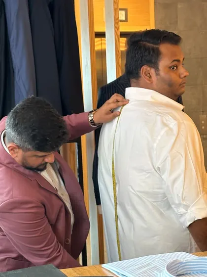 Taking precise measurements at our trunk show. We bring the full bespoke experience to you, ensuring a perfect fit no matter the location.