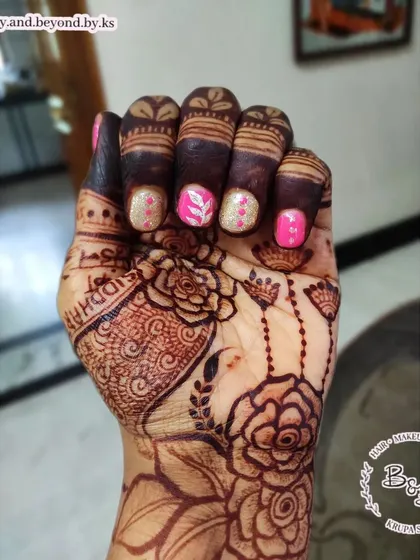 This gel polish set on short nails was for a client attending a Mundan ceremony. The design features pink and gold glitter polish with a delicate, hand-painted white leaf design.