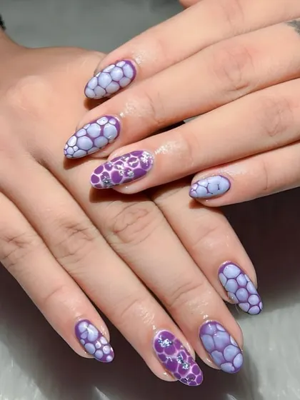 This unique design mimics the look of reptile skin or bubbles, created with a special technique in shades of purple.