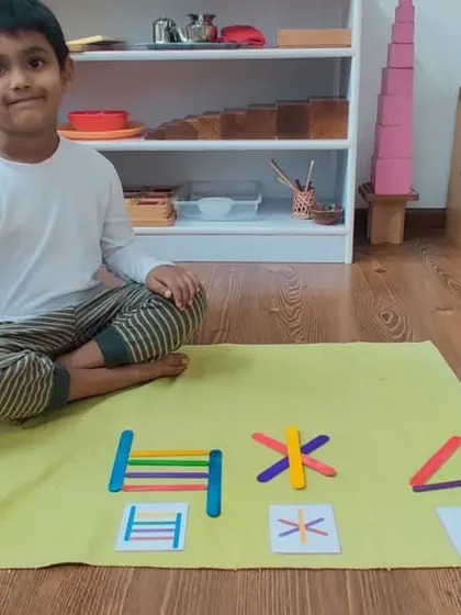 Perfect implementation. After being shown how to create geometric shapes with craft sticks, this child has independently recreated the patterns. This shows his ability to observe, concentrate, and execute a task with precision.