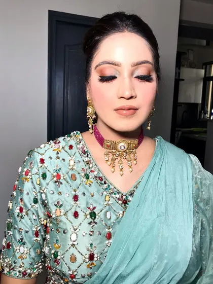An eyes-closed shot of the powder blue saree look, showing the matte eyeshadow.