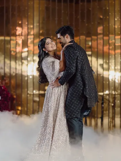 The couple shares a romantic dance, surrounded by theatrical smoke for a dreamy effect.