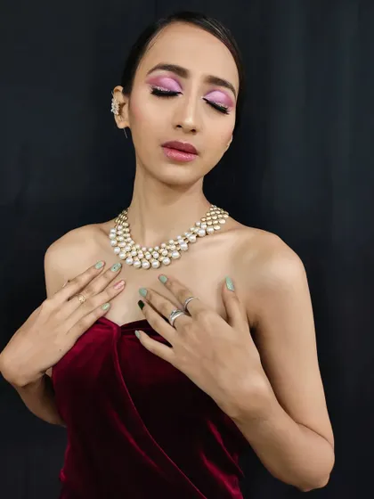 The complete look, showing how the pearl necklace and velvet dress create a luxurious feel that is perfectly matched by the glamorous makeup.
