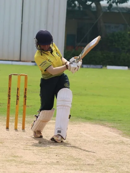 A batter executes a powerful shot during a women's match at our ground. Our turf pitch provides a reliable surface for expressive stroke play.