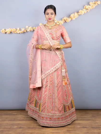 A classic, elegant pose in the pastel peach lehenga, perfect for capturing timeless memories.