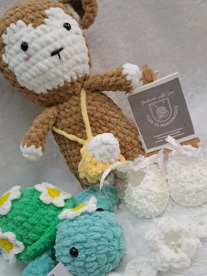 A wonderful custom gift set including a monkey doll, a plush turtle, and a full baptism accessory set with pearl-studded booties and a headband.