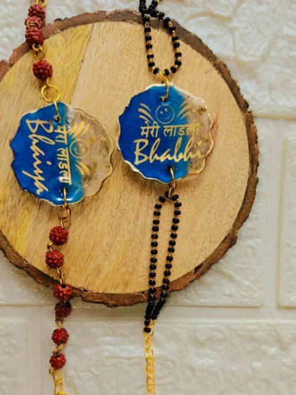 A special rakhi set for your bhaiya and bhabhi. This resin rakhi and lumba set features the phrases "Mera Laadla Bhaiya" and "Meri Laadli Bhabhi" in Hindi.
