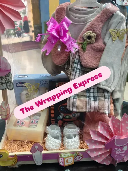 The final look of the baby girl hamper with the cute winter outfit, decorated with pink bows and paper fans.