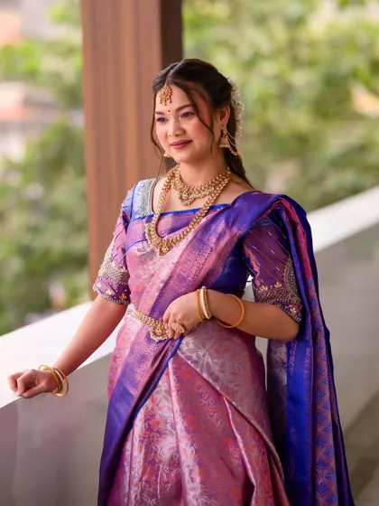 Another angle of the bride on a balcony, looking serene and beautiful. The soft hairstyle and radiant makeup complement the elegant saree perfectly.