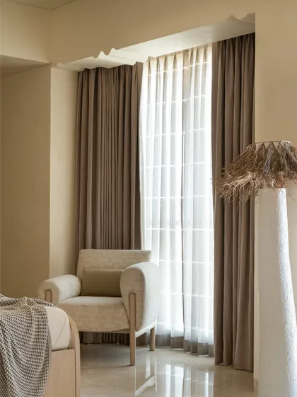 A detail of the bay window seating area, showing the scalloped motifs and the soft, comfortable armchair.