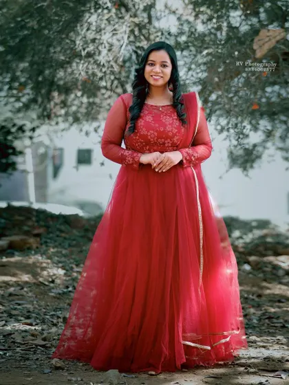 A client looking lovely in a red Anarkali gown with delicate floral embroidery. It's a classic and timeless choice for any celebration.