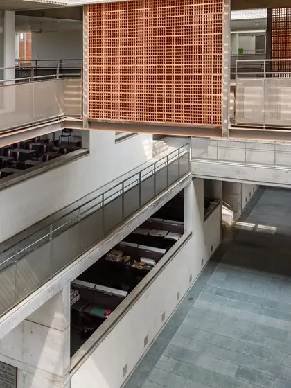 An interior view at VIT showing the use of perforated brick screens (jaalis) to filter light and allow for ventilation while maintaining privacy.