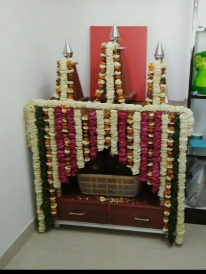 We provide decoration services for even the smallest home temples (mandirs). Here, we created a small structure around the temple using garlands of fresh white, pink, and red flowers.